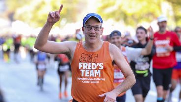 David Slutsky raises one hand in a fist pump while running a race. 