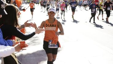 Diana Cruz Solash high-fives fans while running a race. 