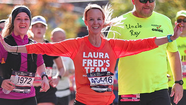 Runners smiling and cheering in bright athletic gear during a marathon.